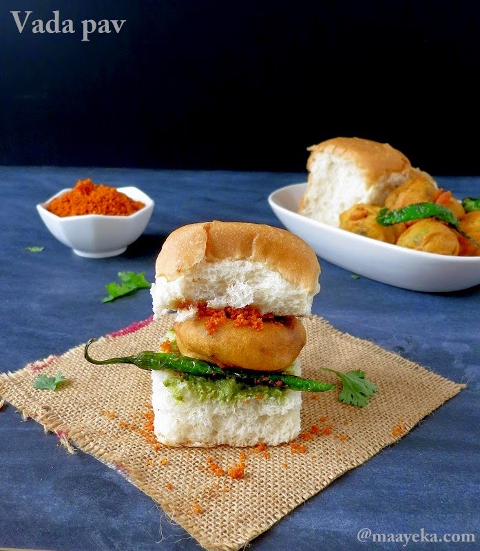 Vada Pav is called the Indian version of a burger. A delicious, spicy, deep-fried patty made of potato is squeezed between a thick slice of bread, similar to a burger bun and is garnished with green chillies and coriander chutney.
